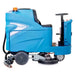 Side view of the blue ride-on floor scrubber showing its seat, steering wheel, scrub decks, and rear squeegee.