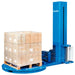 Blue stretch wrap machine with a pallet load on the turntable, showing the film carriage beside the wrapped load.