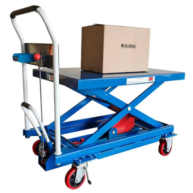 Global Industrial mobile scissor lift table raised with a box on the platform, showing the foot-operated hydraulic lift and hook-on parts bin.
